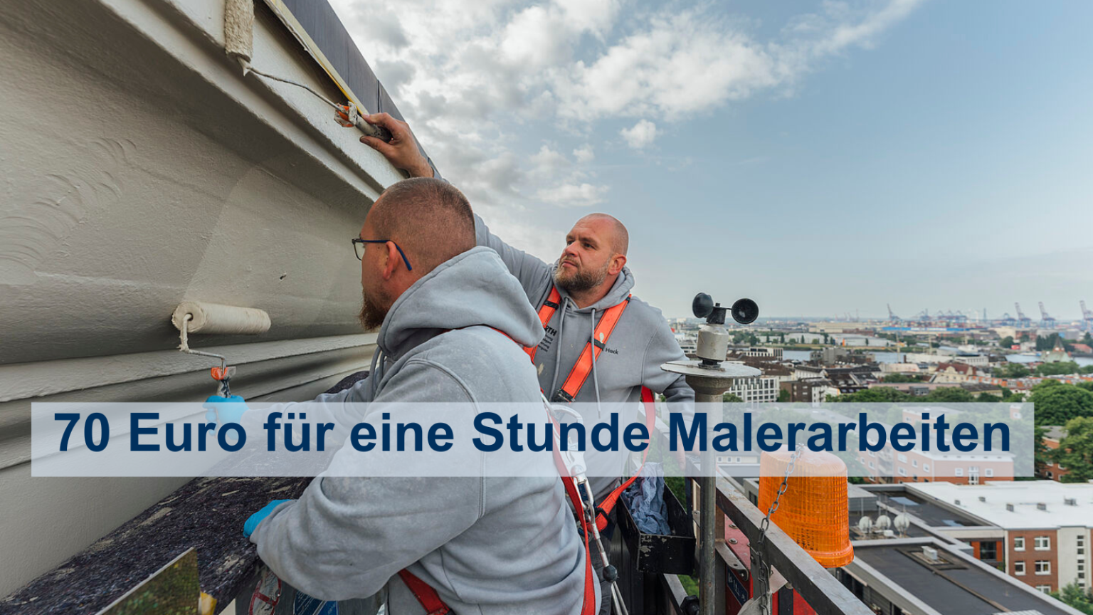 Zwei Maler stehen auf einem Steigbügel hoch über der Staft und Malen die Fassade des Michel an. Im Hintergrund ist die Elbe zu sehen.