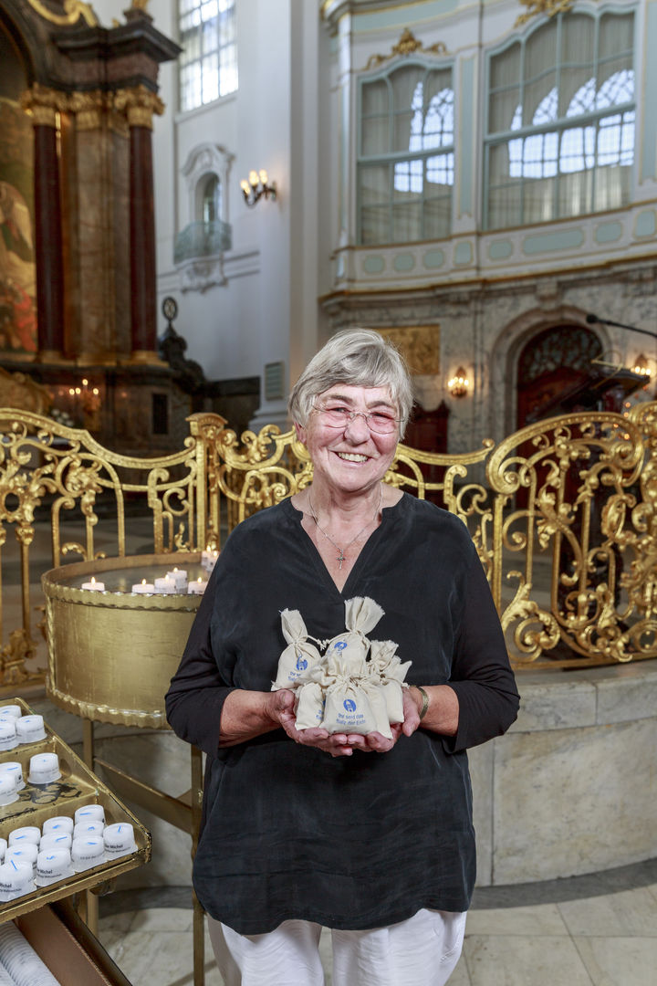 Heike Wisch, selbsternannte "Salzbotschafterin," mit Michel-Salz Päckchen in ihren Händen vor dem Altarraum des Michel
