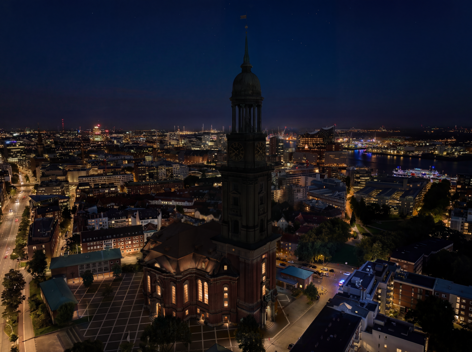 Der Michel in Vogelperspektive ohne Beleuchtung bei Nacht. Der Michel ist kaum zu erkennen, vor allem der Turm ist dunkel.
