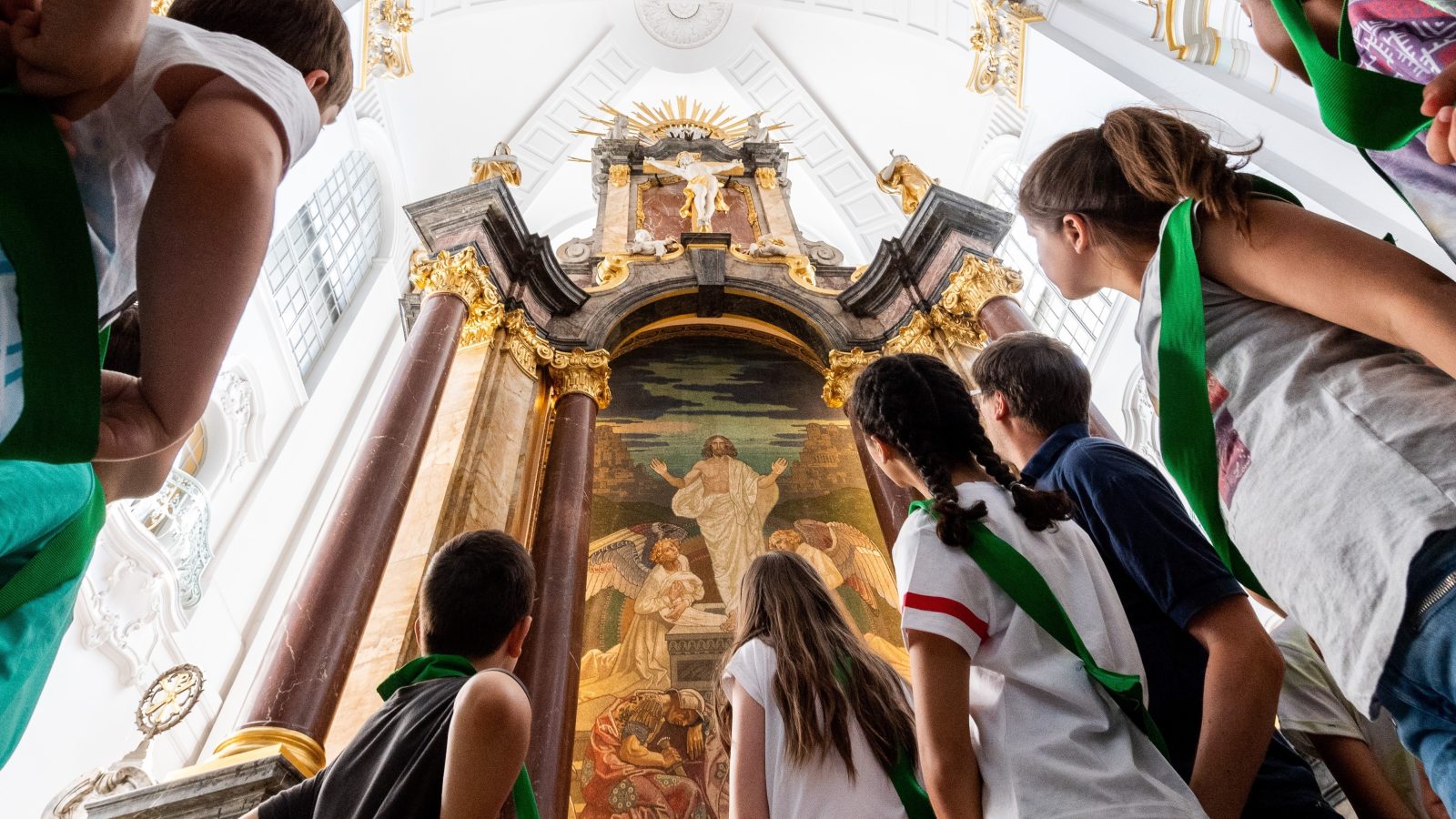 Eine Kindergruppe steht vor dem Altar des Michel und schaut hinauf