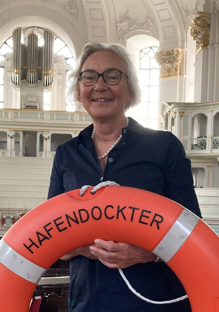 Elke Pahl-Weber mit einem Rettungsring auf der Nordempore im Hintergrund die CPE Bach Orgel
