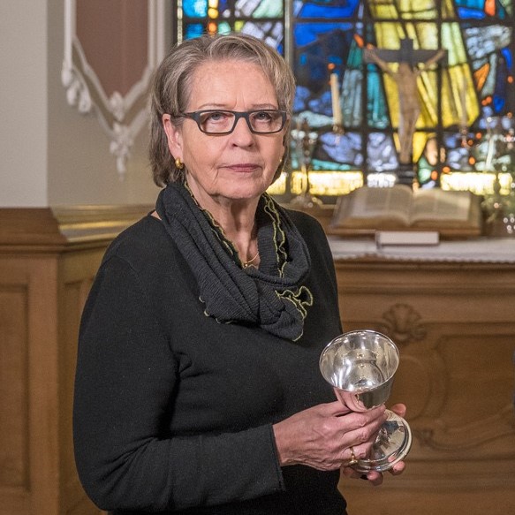 Silberschmiedin Margarete Oehlschlaeger im Altarraum des Michel mit einem Abendmahlkelch in ihren Händen