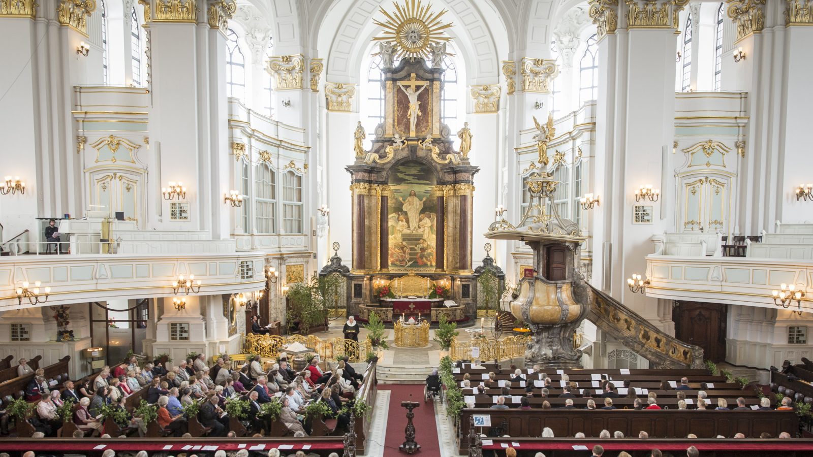 Gemeinde feiert den Pfingstgottesdienst im mit grünen Birkenzweigen geschmückten Kirchraum des Michel