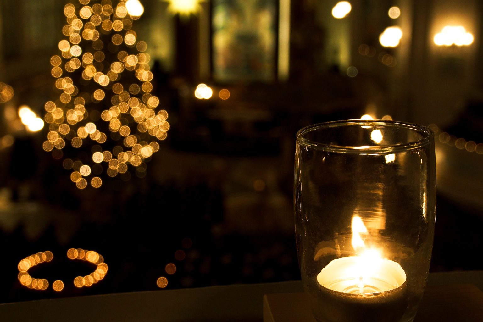 Ein brennendes Windlicht im weihnachtlich geschmückten Michel