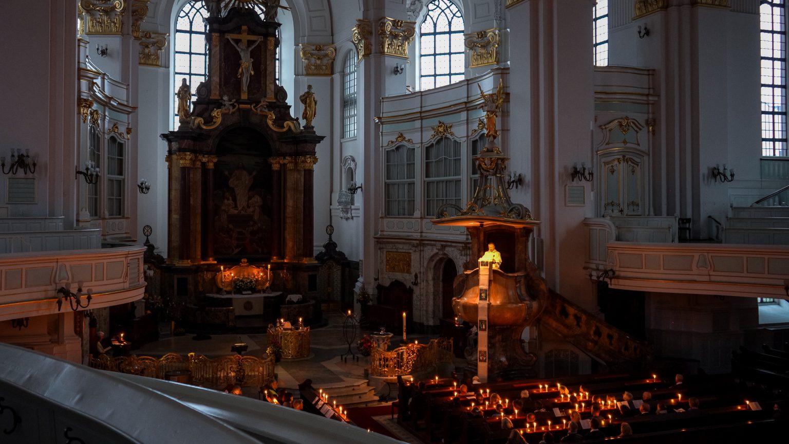 Gottesdienst am Ostermorgen im Michel. Das Licht der vielen Kerzen erhellt den noch dunklen Kirchraum.
