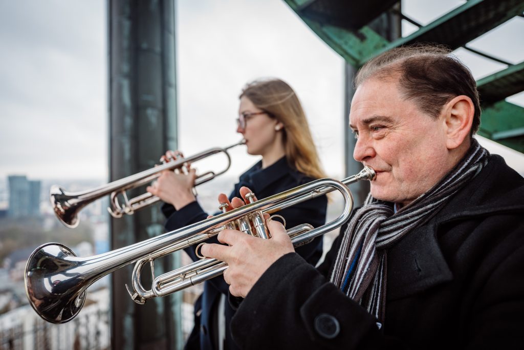 Türmerin Neele Laudien und Türmer Joseph Thöne spielen Trompete auf der Aussichtsplattform