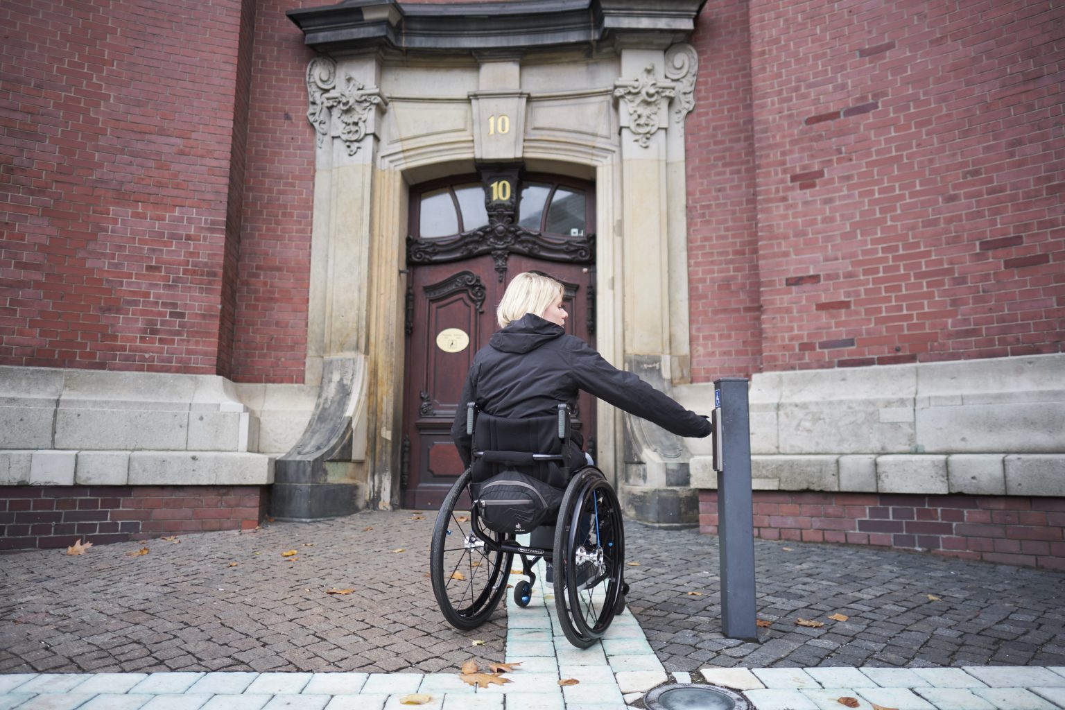 Frau in Rollstuhl vor Portal 10