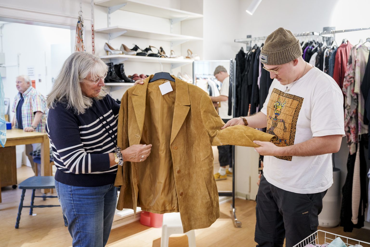 Im Secondhandladen Jack un Büx probiert ein Kunde eine Lederjacke an.