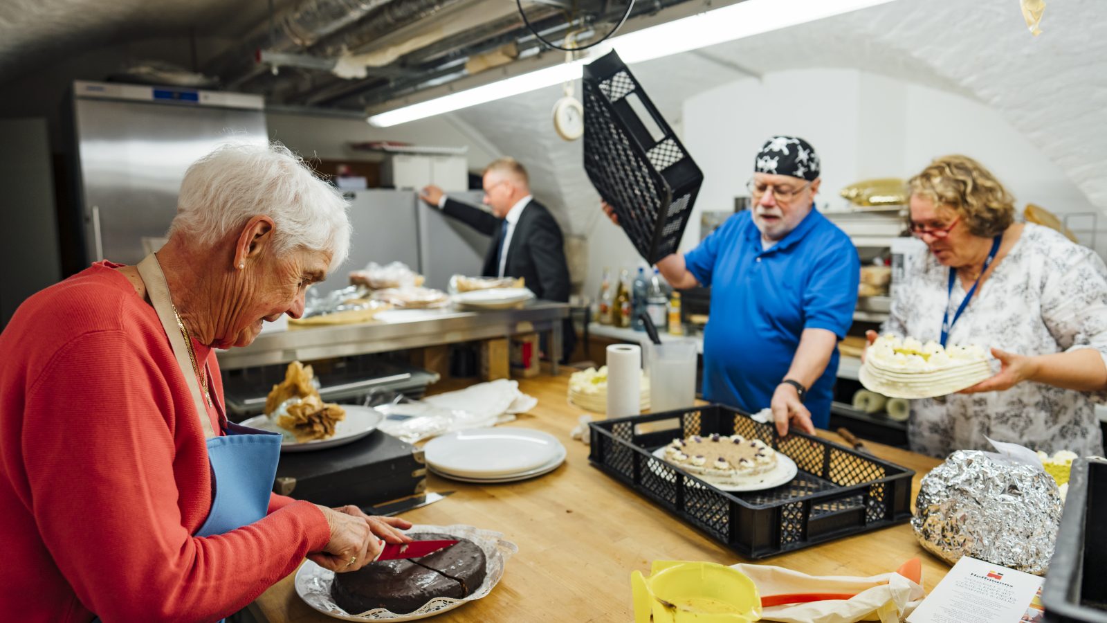 Drei Ehrenamtliche bereiten die Kuchen für die Sitftungsversammlung der Stiftung St. Michaelis vor.