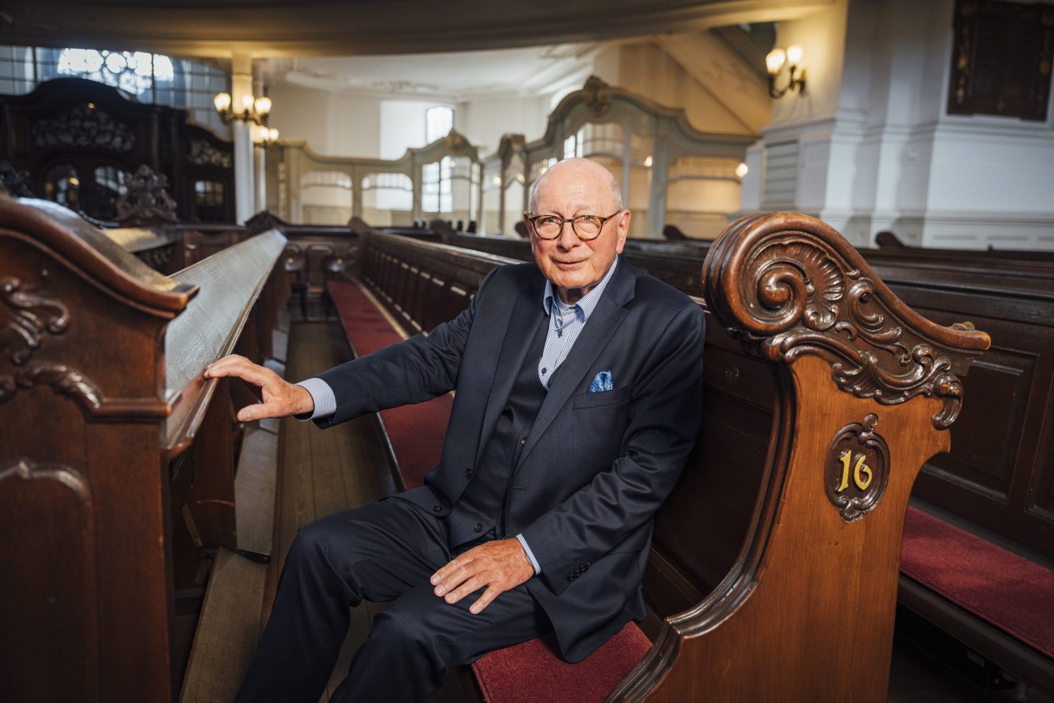 Michael Gierlichs sitzt im Anzug in der Michel-Bank.