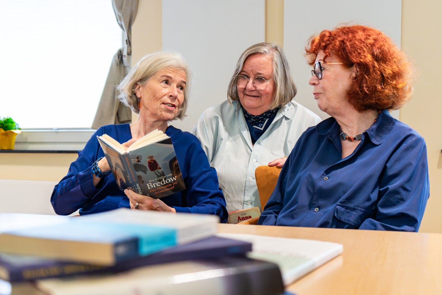 Drei Frauen lesen gemeinsam in einem Buch